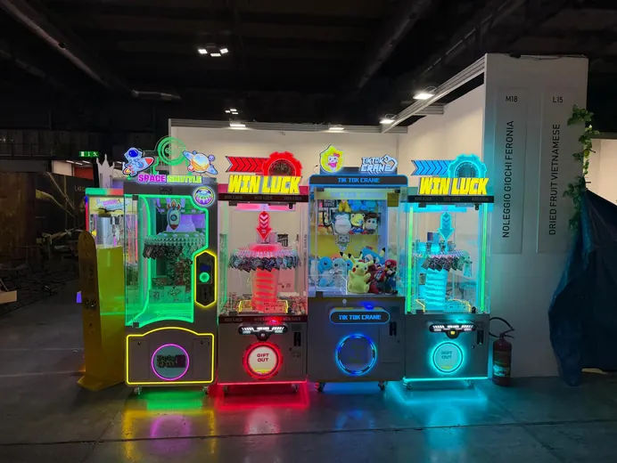 Lo stand di Noleggio Giochi Feronia visto di fronte, con le gru illuminate al neon
